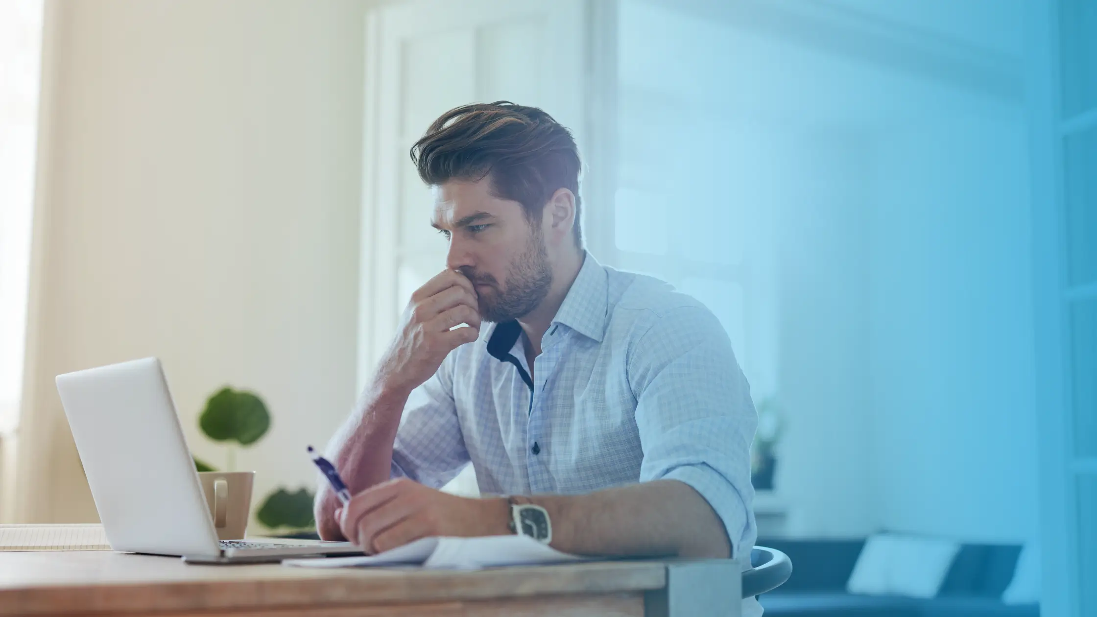 Man working on a laptop at his desk while researching online nandrolone prescription and telehealth treatment options